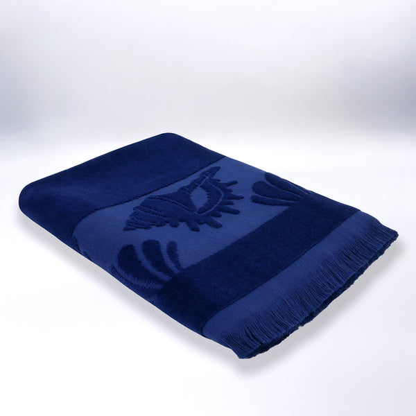 Serviette de plage ciselée bleue Kelly pliée, en velours jacquard doux et absorbant.