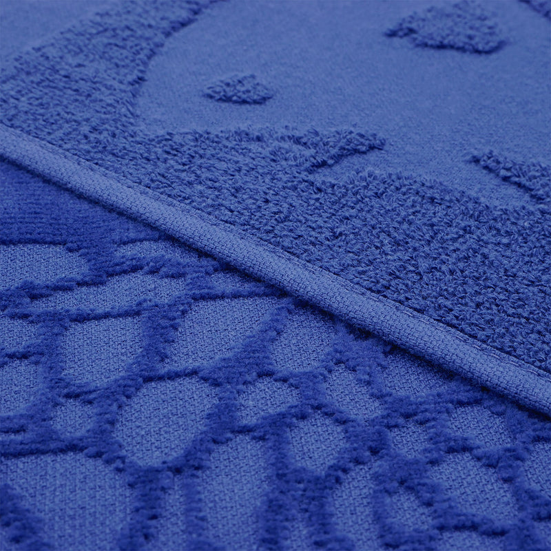 Gros plan sur la texture ciselée de la serviette de plage Kelly en velours jacquard.