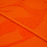 Gros plan sur la texture ciselée de la serviette de plage Kerlaz en velours jacquard.