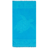 Serviette de plage ciselée Kumini en velours jacquard bleu, motif tortue et franges aux extrémités.