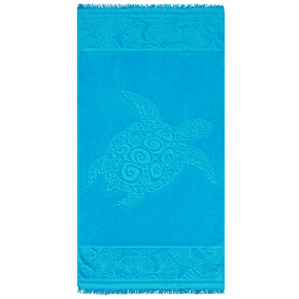 Serviette de plage ciselée Kumini en velours jacquard bleu, motif tortue et franges aux extrémités.