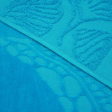 Gros plan sur la texture ciselée de la serviette de plage Kumini en velours jacquard.