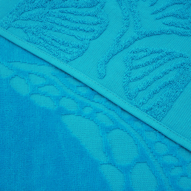 Gros plan sur la texture ciselée de la serviette de plage Kumini en velours jacquard.