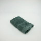Serviette invité grise 100% coton en éponge bouclette, douce et ultra-absorbante, idéale pour un séchage rapide et élégant.