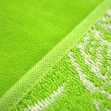 zoom serviette de plage éponge velours jacquard cosmo vert 90x170cm douce, absorbante et élégante, parfaite pour plage et piscine.