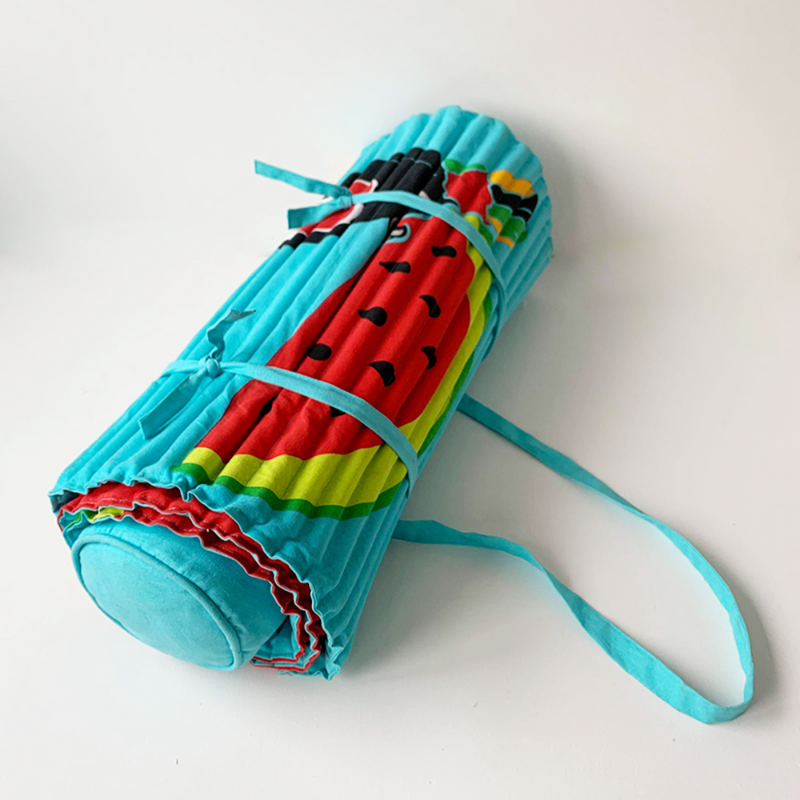 matelas de plage Watermelon fond turquoise  coloris pop vitaminés motifs pastèque et toucan  avec oreiller intégré. Facile à porter avec son anse en bandoulière