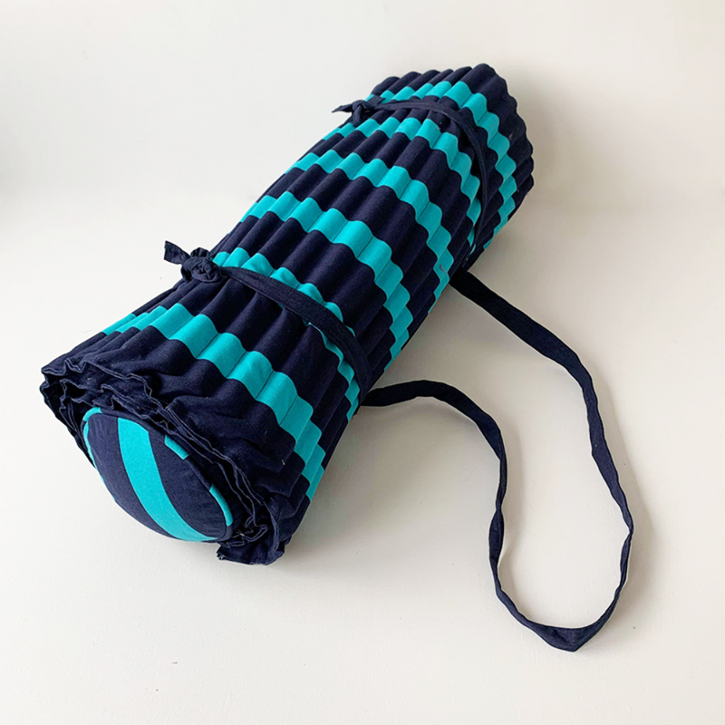 Matelas de plage rayé marine et turquoise  Facile à emporter grâce à sa bandoulière, ce matelas de plage apporte un super confort sur les plages de sable ou de galets . Avec ses rayures indémodables, il est idéal pour vos sorties à la plage ou sur votre transat au bord de la piscine. Très agréable grâce à sa qualité extérieure 100 % coton, il est également très confortable avec son coussin intégré. A shopper également sur le site les sacs et serviettes de plage coordonnés.